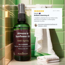 Load image into Gallery viewer, Almond and sunflower oil anti-ageing cleansing oil bottle in green bathroom setting with white towels and a 5-star customer review excerpt