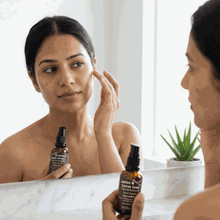 Load image into Gallery viewer, Woman applying VLEssentials Lemon & Carrot Seed Pigmentation Dark Spots Face Serum in front of mirror