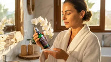 Load image into Gallery viewer, Woman applying VLEssentials Anti-Ageing Oil Cleanser with almond and sunflower oil in bathroom