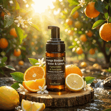 Load image into Gallery viewer, VLEssentials foaming facial wash with orange blossom and lemon for pigmentation and dark spots, 100ml bottle displayed with fresh oranges, lemons, and orange blossoms in sunlight.
